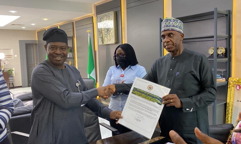 Acting Director General of the ICRC, Mr Michael Ohiani presenting an FBC certificate of compliance to the Minister of Transportation Rotimi Amaechi