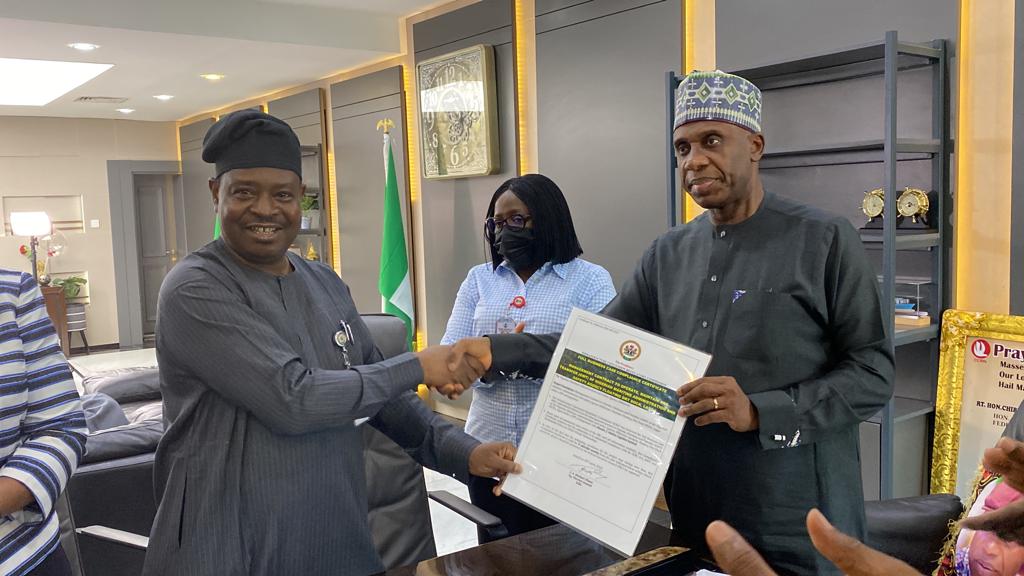 Acting Director General of the ICRC, Mr Michael Ohiani presenting an FBC certificate of compliance to the Minister of Transportation Rotimi Amaechi