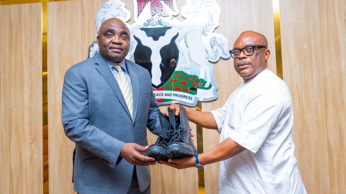Dr. Jimmy Ntuen, Chairman of Erojim Investments Limited, presents shoes manufactured for Nigeria's paramilitary agencies to Dr. Jobson Oseodion Ewalefoh, Director General of the Infrastructure Concession Regulatory Commission (ICRC).